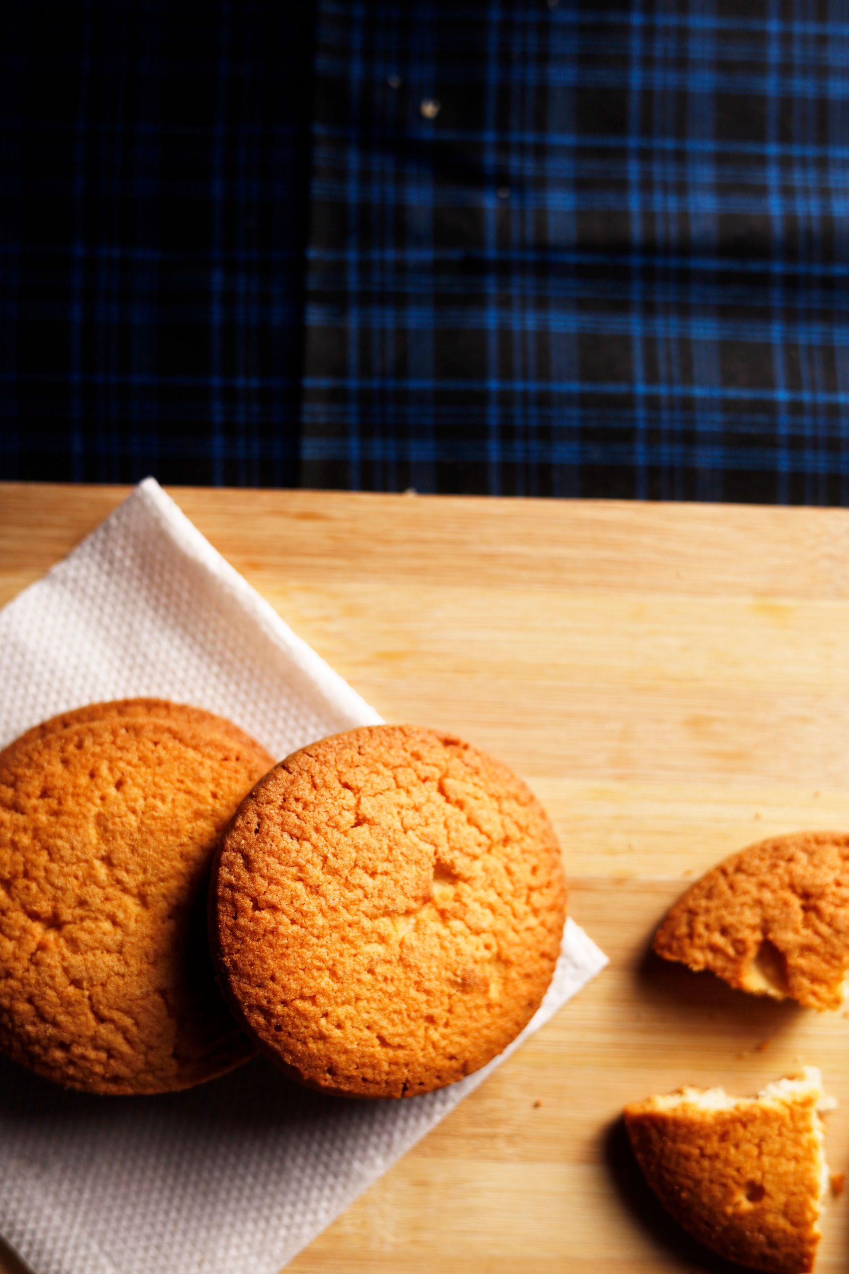 Close-up of freshly baked golden cookies arranged on a wooden board, offering a warm and delicious look.